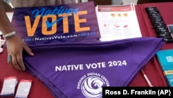 FILE - Voter information is on display at a Phoenix Indian Center booth during an Indigenous Peoples' Day event in Phoenix, Arizona, Oct. 14, 2024. 